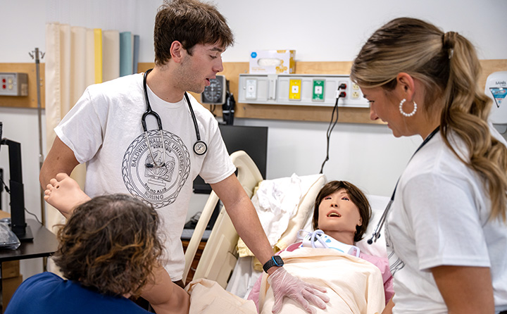 photo of students and professor by birthing simulator